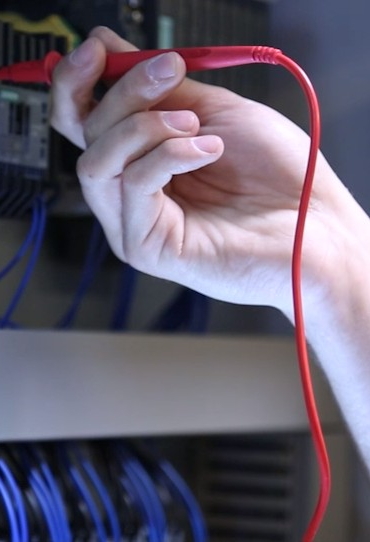 Hand hält Stromkabel