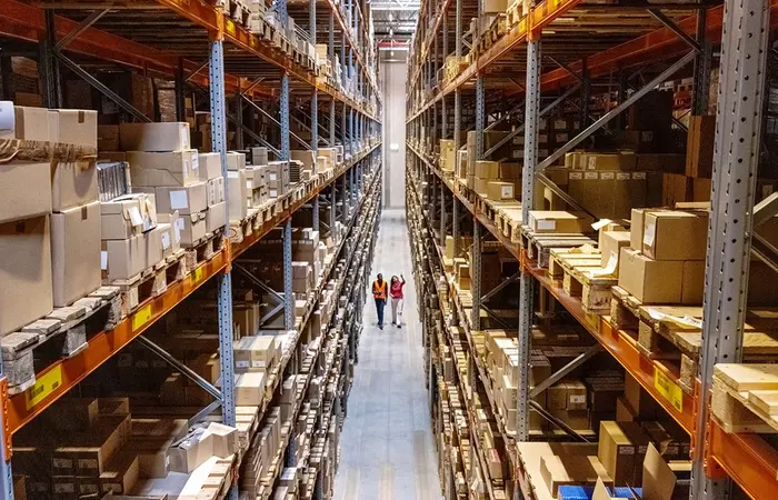 Zwei Personen laufen durch ein großes Lager