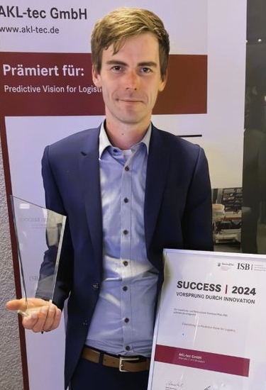 Maikel Boerebach mit einem Pokal und einer Urkunde in der Hand bei der Preisverleihung für Predictive Vision for Logistics 2024