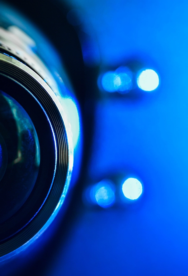 Detailaufnahme einer Kameralinse mit blauem Hintergrund