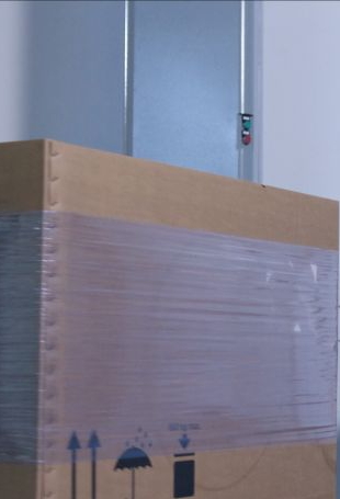 Auf einen Karton wird ein Versandlabel mittels redtagger aufgebracht