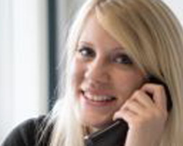 Blonde Frau im Büro am Telefon