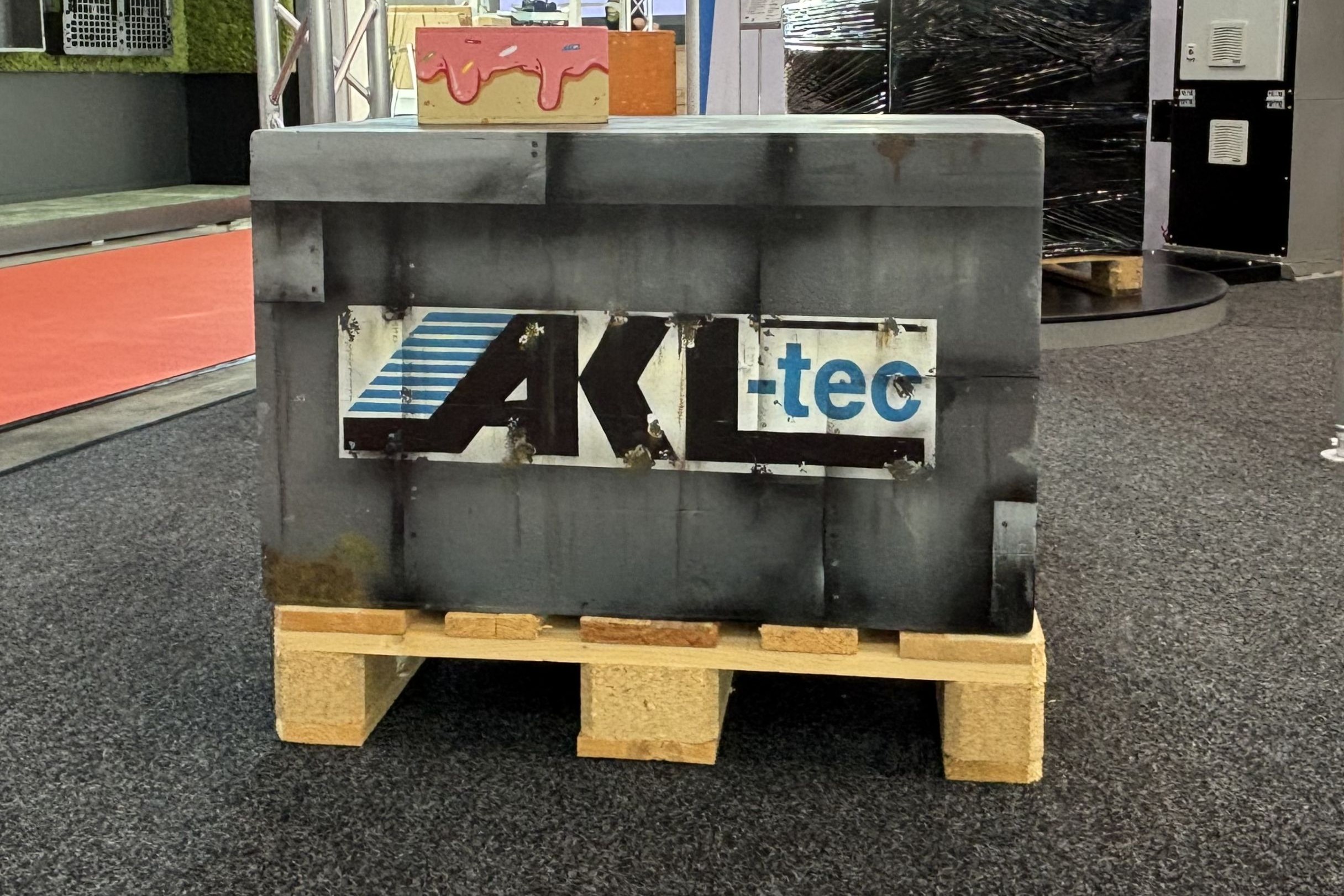 Eine schwarze Transportkiste mit AKL-tec auf einer Palette