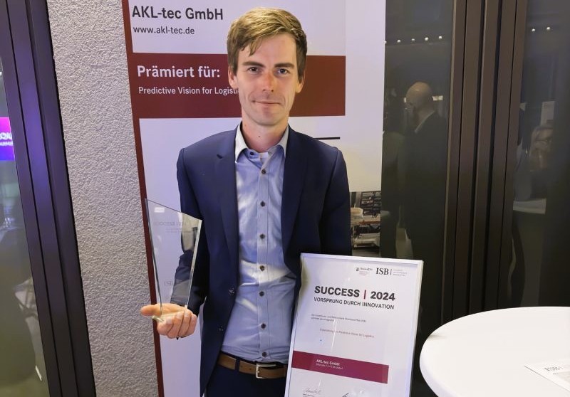 Maikel Boerebach mit einem Pokal und einer Urkunde in der Hand bei der Preisverleihung für Predictive Vision for Logistics 2024
